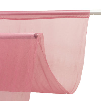 Sheer pink fabric draped elegantly on a rod.