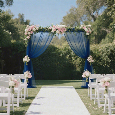 Wedding arch with blue drapes and floral arrangements in a garden setting.