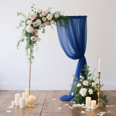 Elegant wedding backdrop with flowers and candles on a wooden floor.