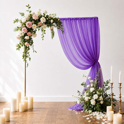 Elegant floral wedding backdrop with purple drapery and candles