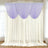 Lavender sheer curtain swag over white drapes in a bright room