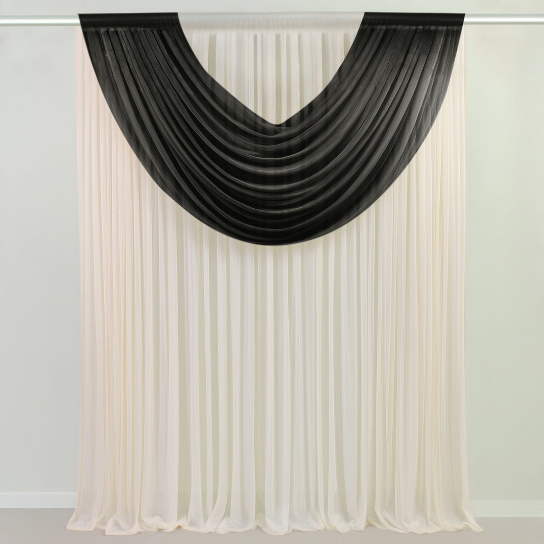 Black sheer curtains draped over white curtains in a room