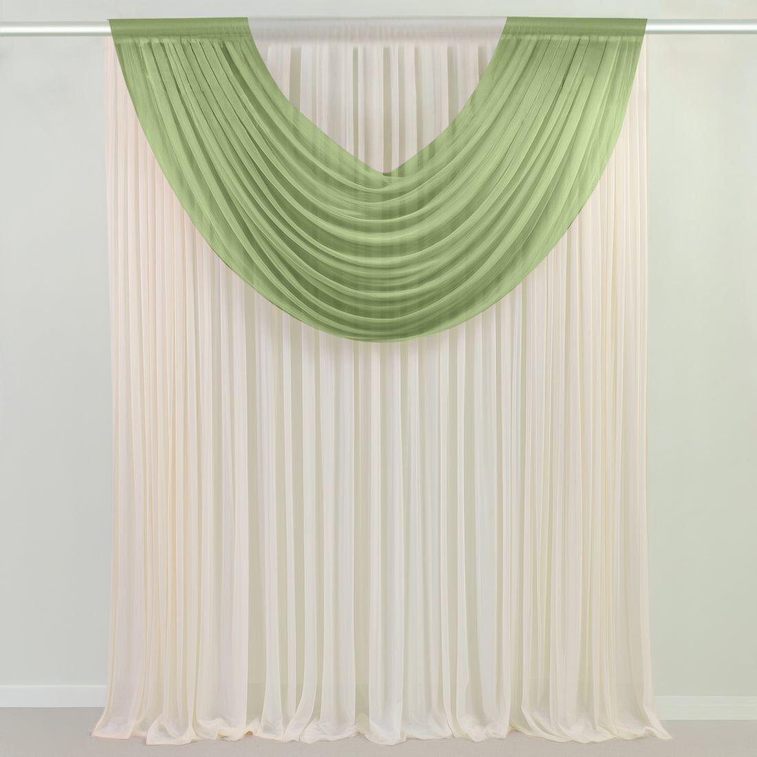 Green and ivory sheer curtains draped over a window rod