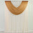 Brown sheer swag curtain panel draped on rod over white wall