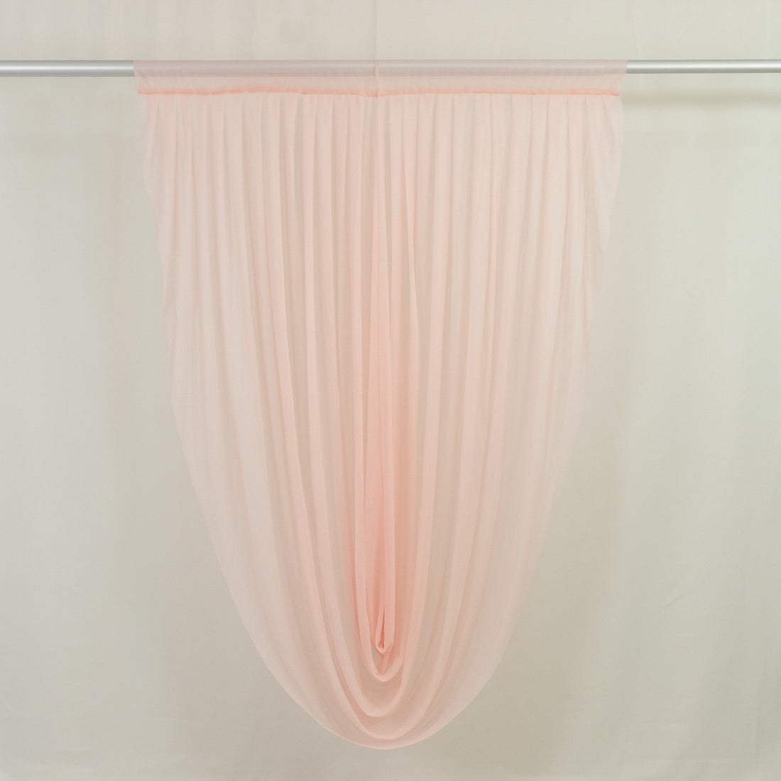 Sheer blush pink window curtain panel on rod