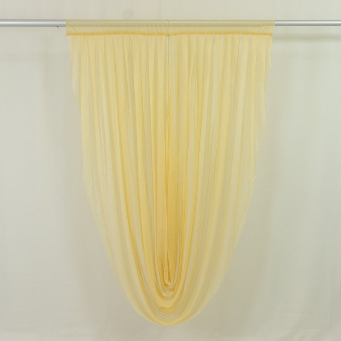Sheer yellow window curtain panel on rod