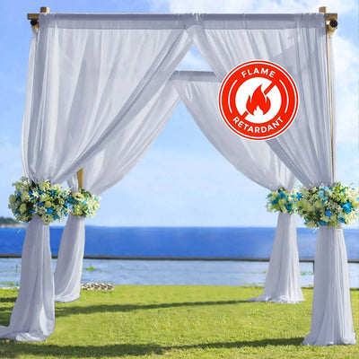 Flame-retardant wedding arch draped in white fabric with floral accents.