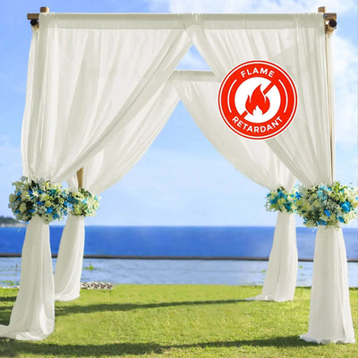 Flame-retardant wedding arch with white drapes and blue floral arrangements.