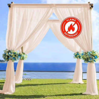 Outdoor wedding arch with drapes and floral arrangements, flame-retardant feature.