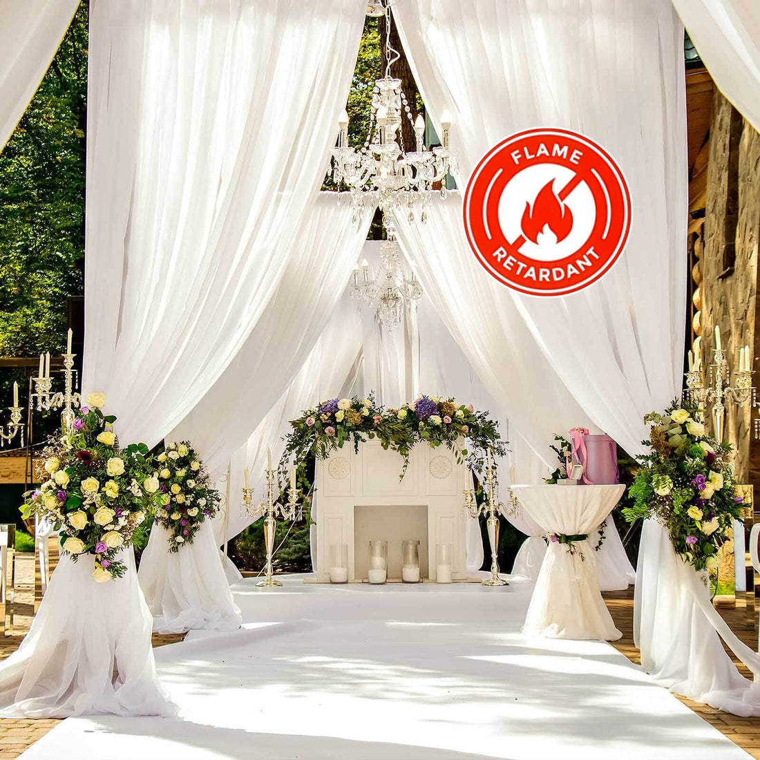 Elegant outdoor wedding decor with floral arrangements and draped fabric.