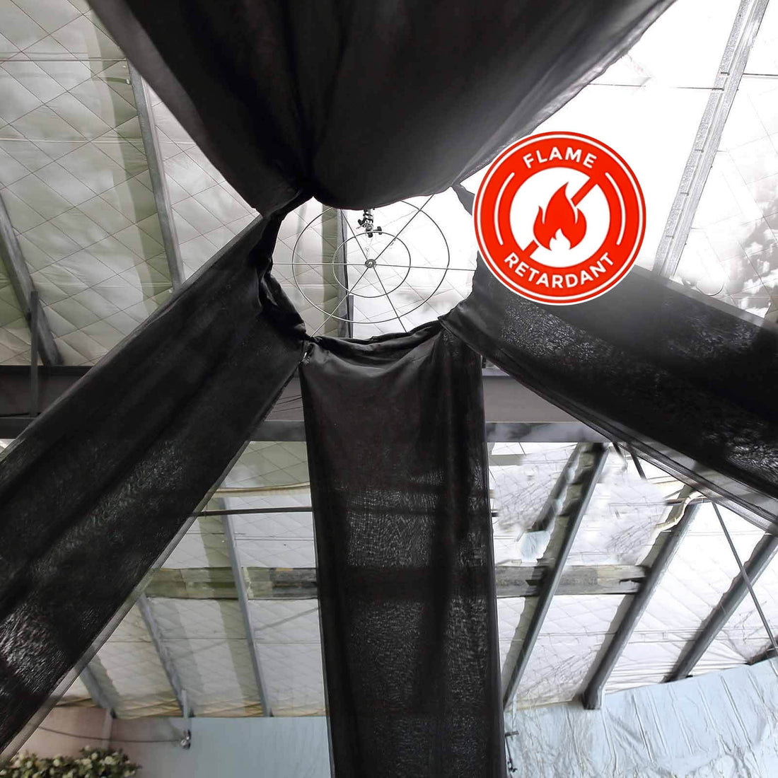 Flame retardant black fabric draping from ceiling in a warehouse setting.