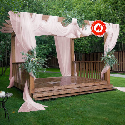 Outdoor wooden gazebo draped with pink fabric and greenery