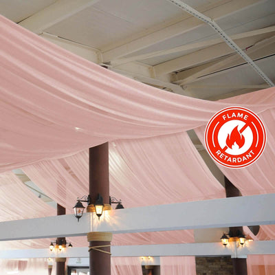 Pink sheer fabric draped across a ceiling with flame retardant symbol.