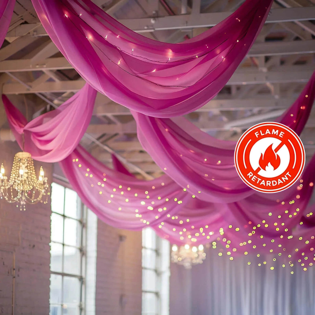 Pink drapery with lights in a decorated venue, featuring a flame retardant label.