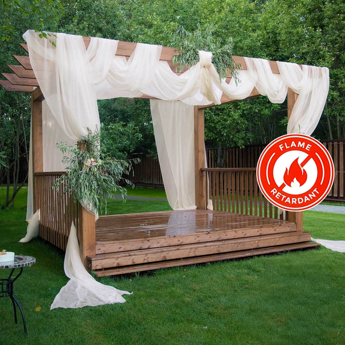 Flame-retardant outdoor wedding pergola with draped fabric and greenery.