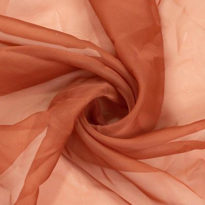 Flowing rust-colored sheer fabric with delicate texture details.