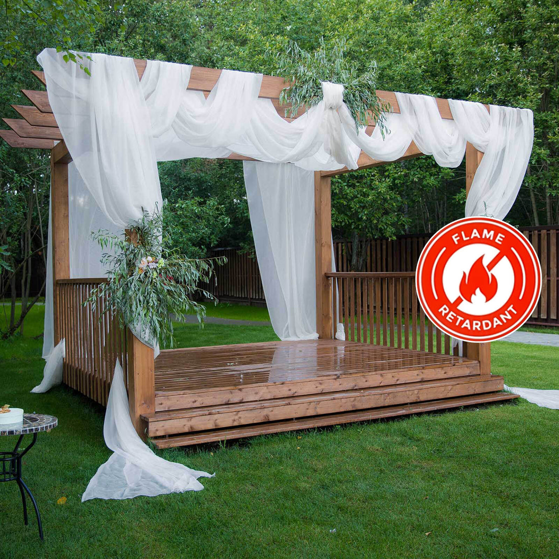 Flame retardant wooden pergola with sheer drapes and greenery in a garden setting.