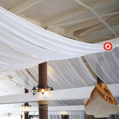White drapery elegantly hung from a ceiling in a spacious venue.