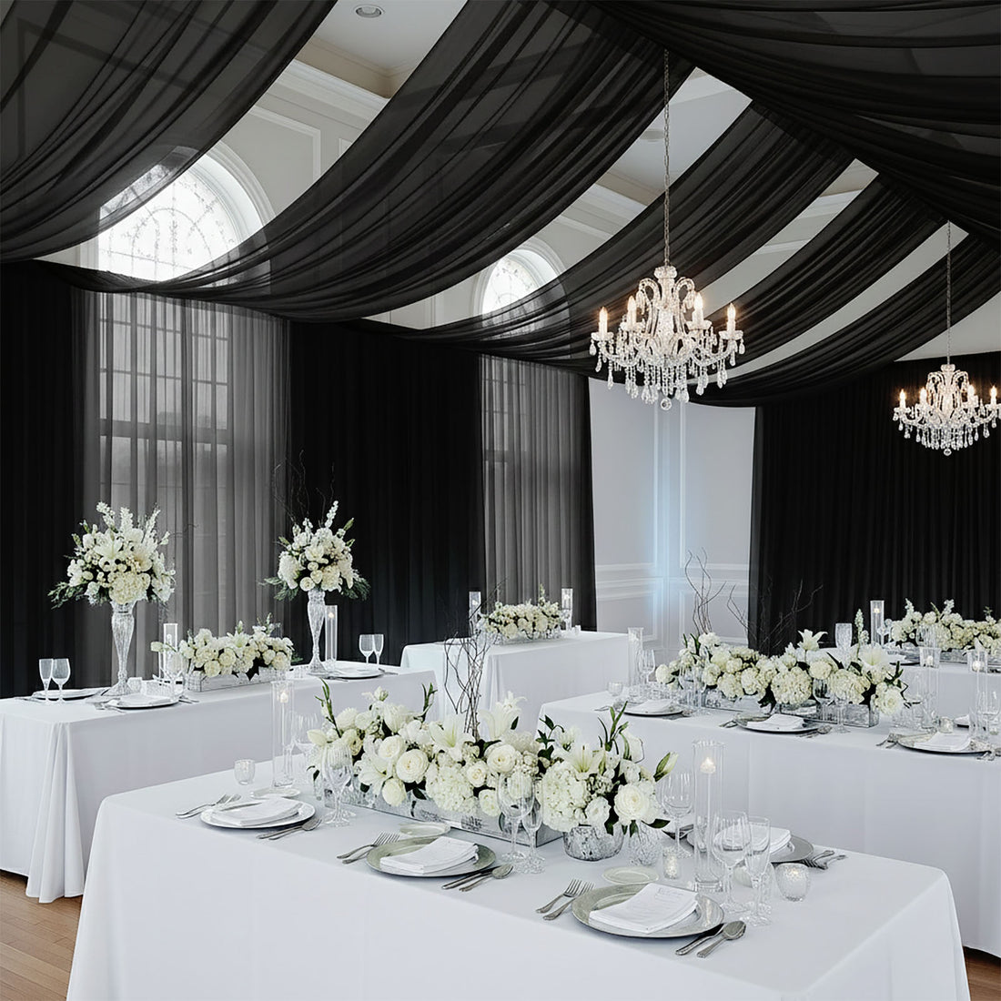 Elegant wedding reception with white floral decor and chandeliers.
