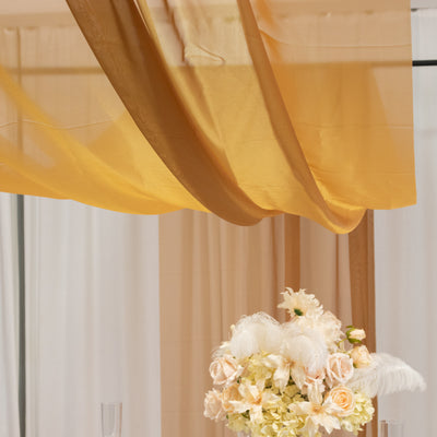 Elegant floral arrangement with draped gold fabric backdrop.