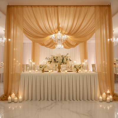 Elegant wedding reception setup with floral centerpieces and soft drapery.