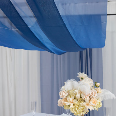 Elegant floral arrangement with soft draped fabric backdrop.