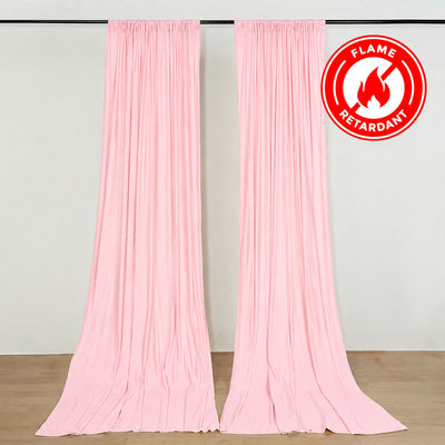 Pink flame retardant curtain panels hanging on a rod, indoor backdrop display