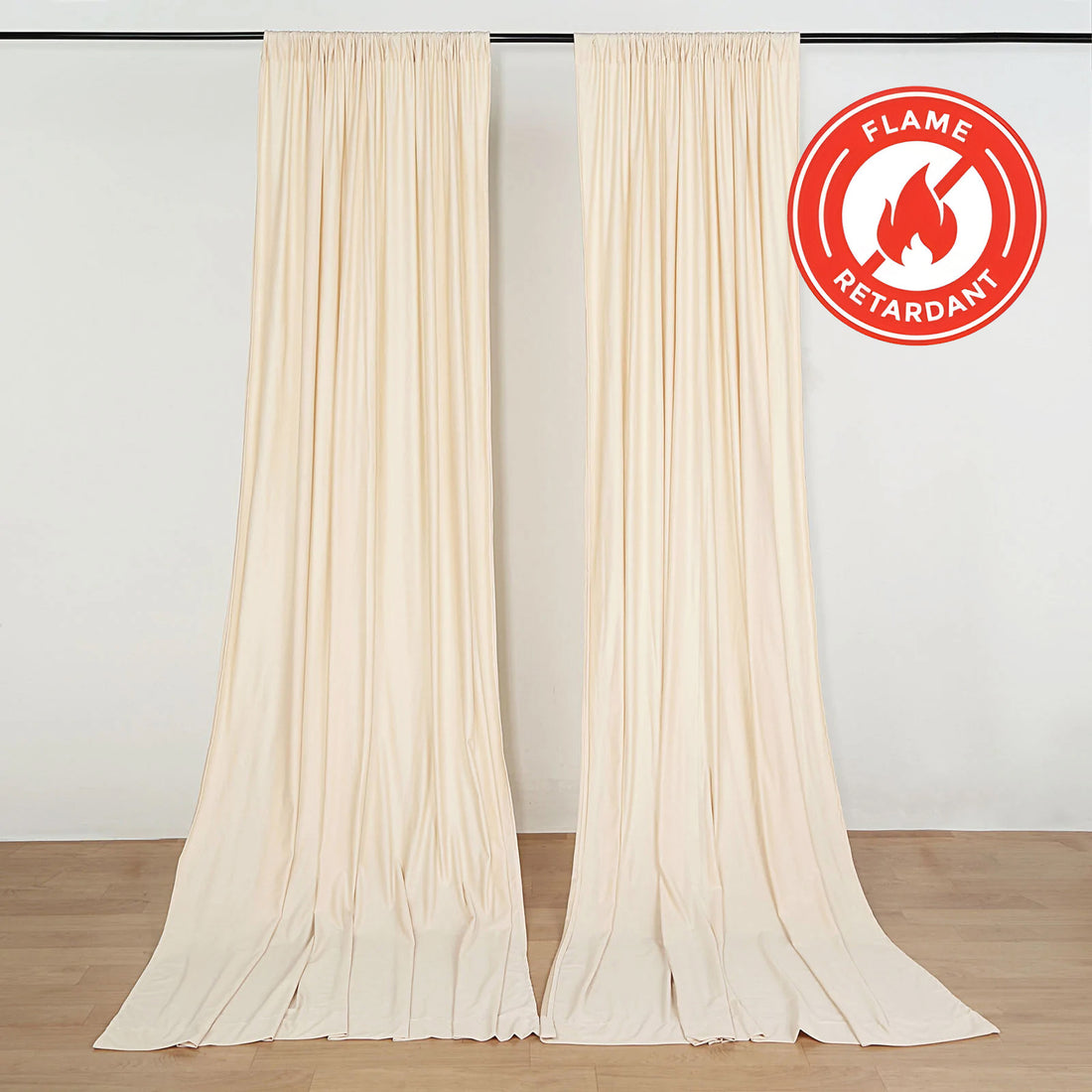 Beige flame retardant curtains hanging against a plain backdrop.