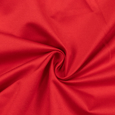 Red ribbed fabric texture with spiral folds close-up
