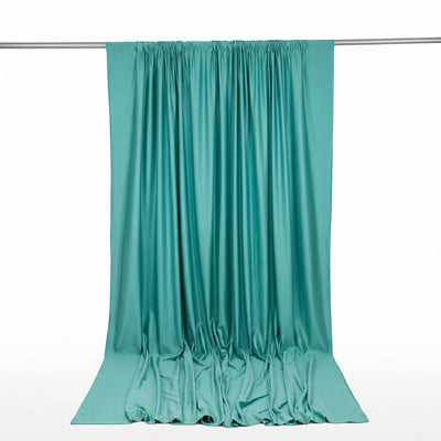 Turquoise satin curtain draped on rod, elegant flowing fabric backdrop