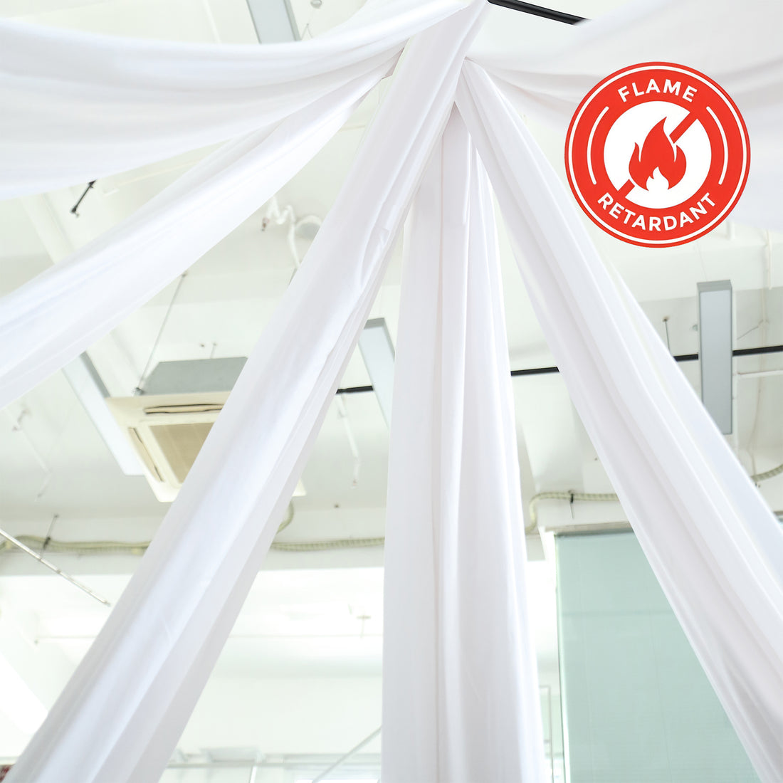 Flame-retardant white fabric drapes in a bright indoor space.