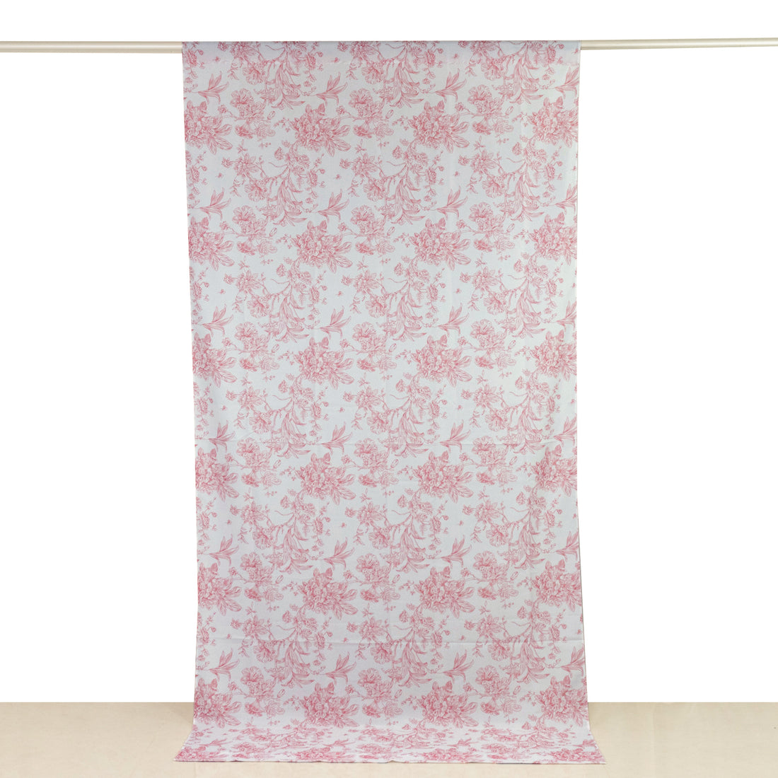 Pink floral patterned fabric hanging on a curtain rod.