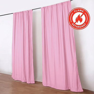 Pink flame retardant curtain panels hanging on a black rod in a room