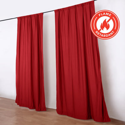 Red flame-retardant curtains hanging on a rod in a room