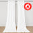 White flame retardant curtains hanging on a rod in a minimalist room