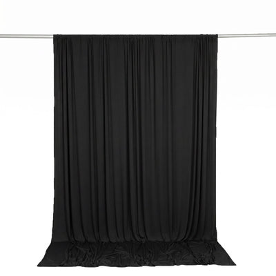 Black draped backdrop curtain on a hanging rod, studio photography background
