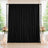 Black wedding backdrop with floral arrangements and candles by window
