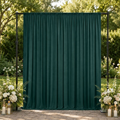 Emerald green wedding backdrop with floral arrangements and candles outdoors