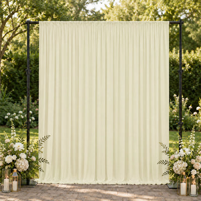 Cream wedding backdrop curtain with floral arrangements and lanterns outdoors