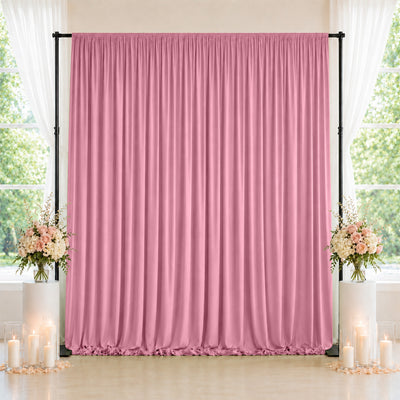 Pink wedding backdrop curtain with floral arrangements and candle decor