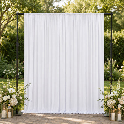 White wedding backdrop with floral arrangements and lanterns outdoors