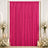Hot pink pleated curtain backdrop with white floral arrangements and candles