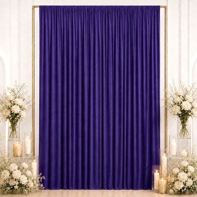 Purple draped wedding backdrop with white flowers and candles