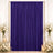 Purple draped wedding backdrop with white flowers and candles