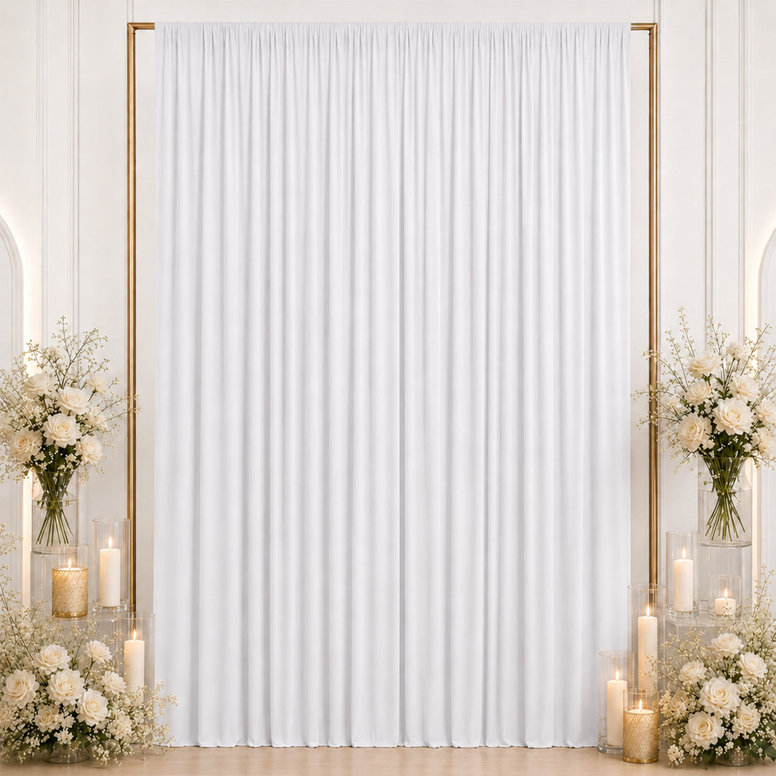 Elegant white wedding backdrop with gold frame, candles, and floral arrangements