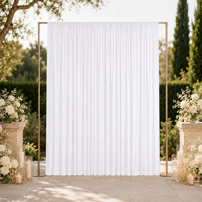 Elegant outdoor wedding backdrop with white drape, gold frame, and floral decor