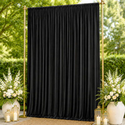Black event backdrop curtain with gold stand and floral arrangements outdoors