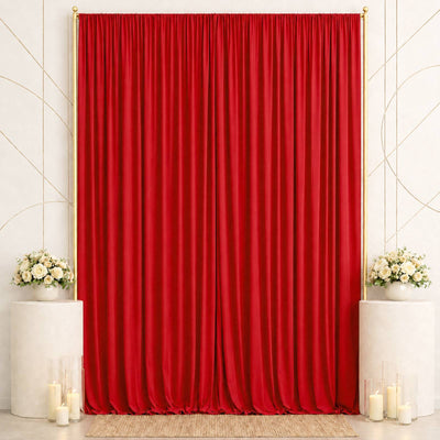 Elegant red velvet curtain backdrop with white floral arrangements and candles