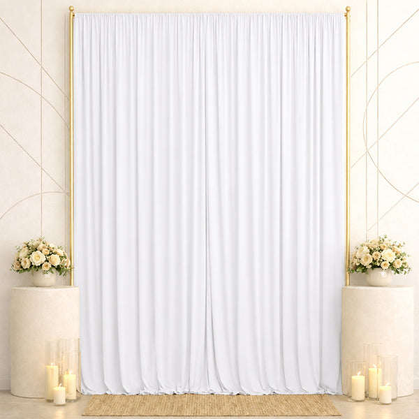 Elegant white wedding backdrop with gold accents, floral arrangements, and candles