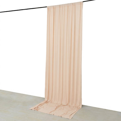 Beige sheer curtain draped from a ceiling rod in a minimalist studio